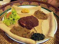المطبخ  [لغات أخرى]‏ الإثيوبي والإريتري النموذجي: إنجيرا (خبز رقيق يشبه الفطيرة) وعدة أنواع من وات (يخنة)